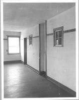 SA0489 - Interior of a Shaker building, showing a window, wall pegs, and door. Identified on the back.
